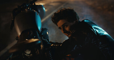 The Groom, portrayed by TimothIe Chalamet, attempts to fix his motorcycle in Lucid’s latest creative campaign, ‒Driven.–