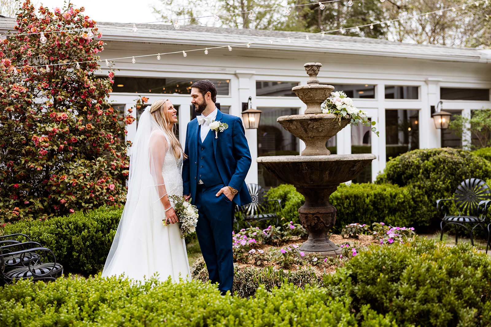 Bride and groom posting in garden courtyard at Primrose Cottage